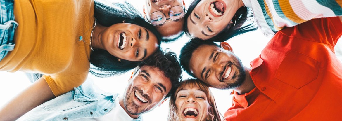 multicultural-community-of-young-people-smiling-at-camera-outside